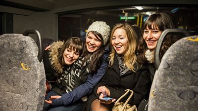 Vier junge Frauen in einem Postauto. 