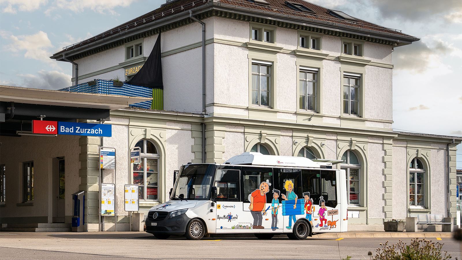 A minibus in front of the Zurzach railway station building