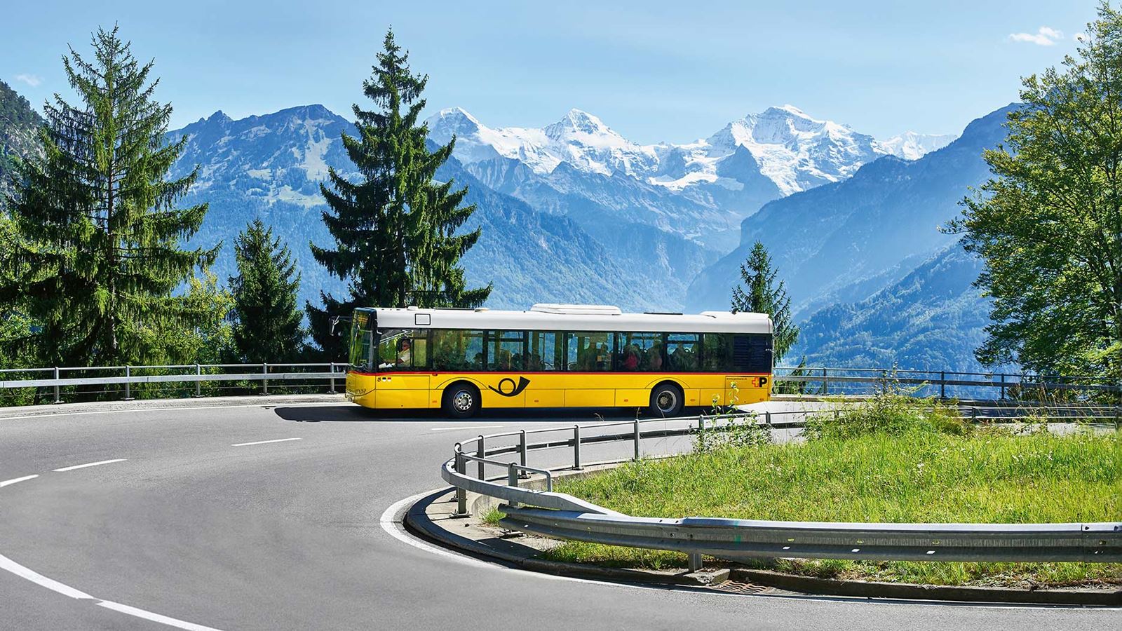 Un car postal roulant en direction de Beatenberg. En arrière-plan, l’Eiger, le Mönch et la Jungfrau.