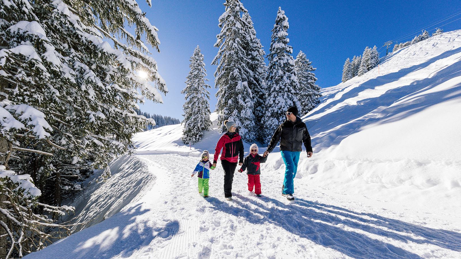 A family on a walk through the snow in winter