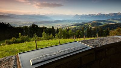 Im Vordergrund Tafel mit Angaben zur Bergkette im Hintergrund. Aussicht auf die Gantrisch-Bergkette und den Thunersee.