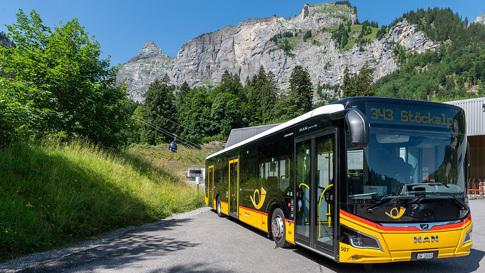 Un car postal devant un panorama de montagnes