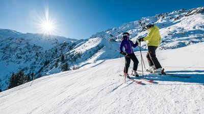 Two skiers heading downhill on the ski slope