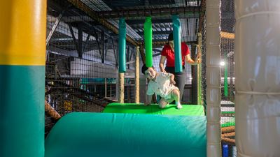 Kleiner Junge und Frau kriechen über Klettermodule im Kiddy Park Bülach.