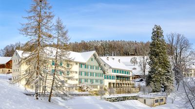View of the Gasthof Gyrenbad in Turbenthal with a snowy landscape.