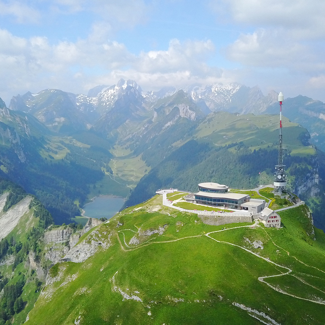 La vue aérienne montre le Hoher Kasten et le lac de Sämtis entouré de montagnes.