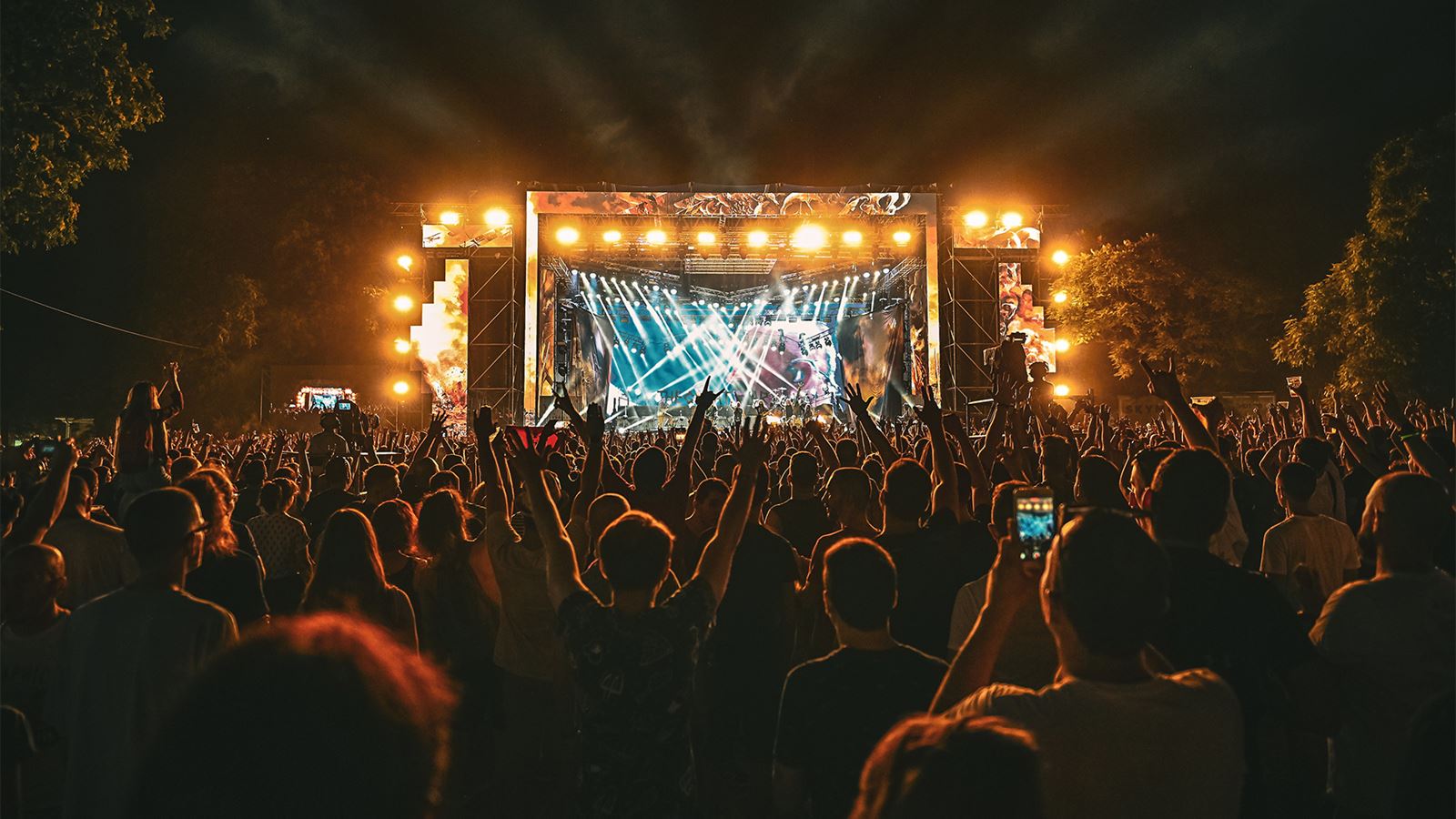 Bühne und Zuschauer an einem Open air Musik-Festival zu sehen.