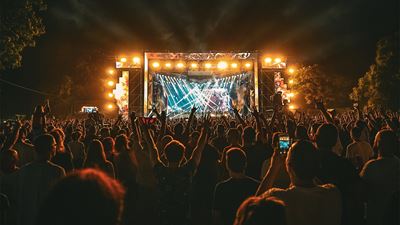Bühne und Zuschauer an einem Open air Musik-Festival zu sehen.