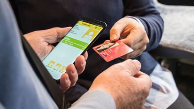 A SwissPass is checked using a PostBus ticket control device.