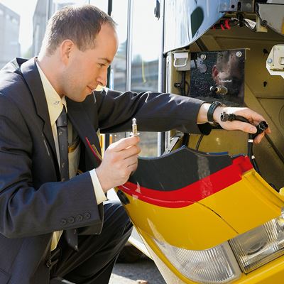 A Postbus driver changing a defective light bulb