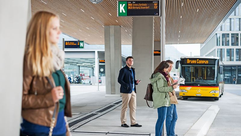 Waiting passengers at the Postbus stop in Brugg.