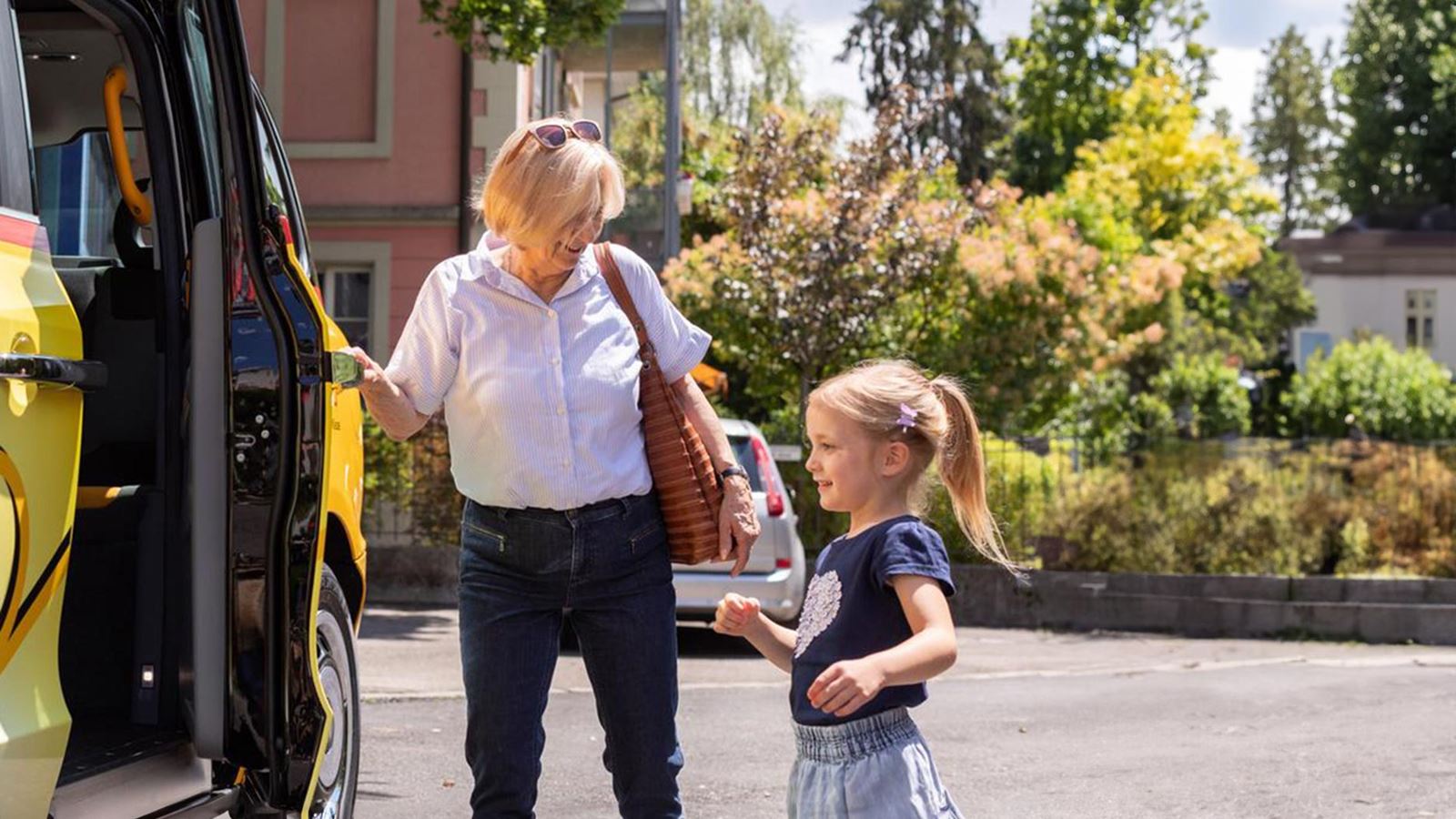 Woman with a small child getting into a PostBus